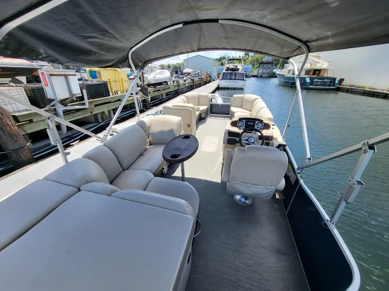 Slide: The Image of 2017 Godfrey Sweetwater 215c pontoon boat with spacious seating and canopy, docked at marina. - 8