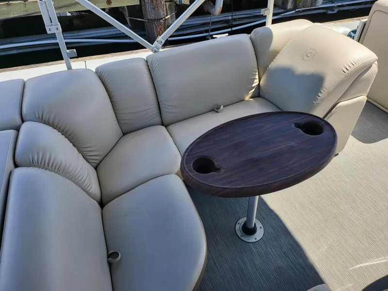 Slide: The Image of Luxurious seating on 2017 Godfrey Sweetwater 215c boat with wooden table and cup holders. - 9