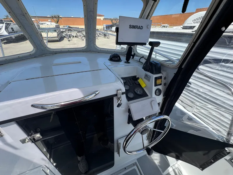 Slide: The Image of 2001 Davis 22 Cortez boat cockpit with steering wheel and navigation equipment. - 10