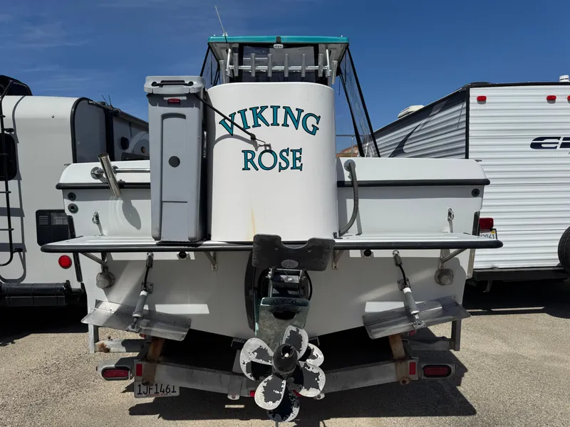 Slide: The Image of 2001 Davis 22 Cortez boat named "Viking Rose" on trailer, parked between RVs. - 3