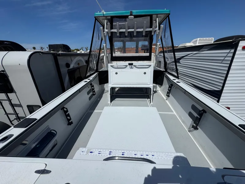 Slide: The Image of 2001 Davis 22 Cortez boat interior with open deck and canopy, parked among RVs. - 5