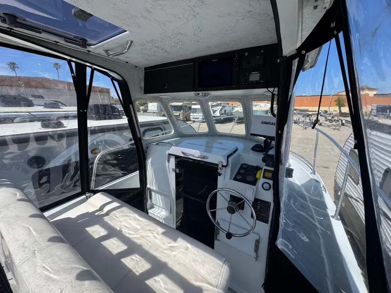 Slide: The Image of Interior of 2001 Davis 22 Cortez boat with steering wheel and seating. - 7