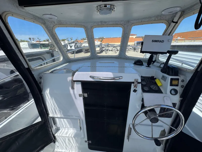 Slide: The Image of Interior view of a 2001 Davis 22 Cortez boat cockpit with steering wheel and navigation equipment. - 8