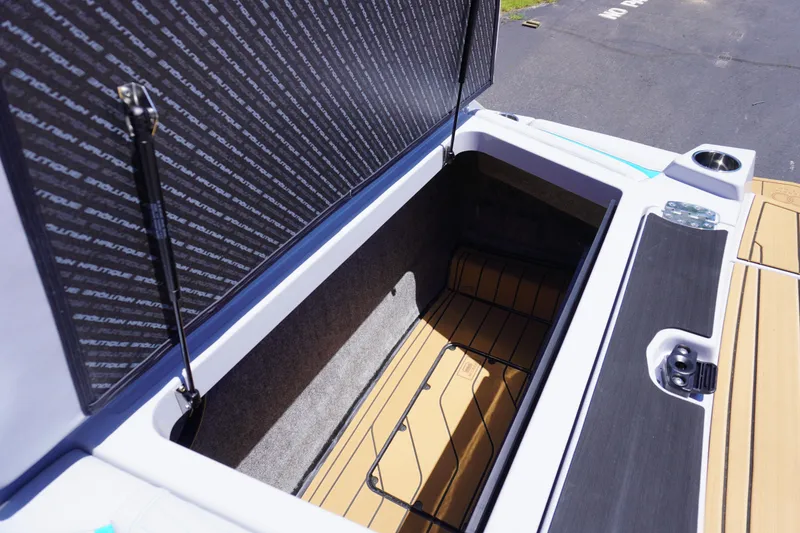 Slide: The Image of 2025 Nautique Super Air Nautique G21 storage compartment with open lid, showcasing spacious interior. - 13
