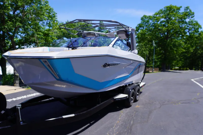 Slide: The Image of 2025 Nautique Super Air Nautique G21 boat on trailer, parked on a sunny day. - 2