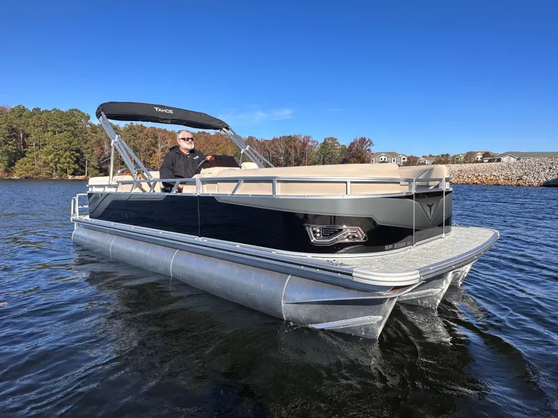 Slide: The Image of 2025 Tahoe Pontoon Sport 85 Quad Lounger on a lake, clear blue sky, scenic background. - 0