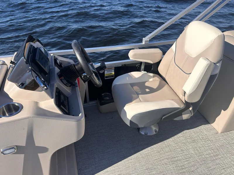 Slide: The Image of 2025 Tahoe Pontoon Sport 85 Quad Lounger helm with beige captain's chair and steering console. - 4