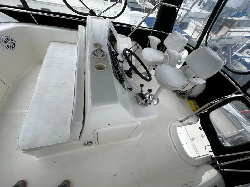 Slide: The Image of Cockpit of 2000 Riviera 34 Convertible boat with steering wheel and seating. - 14