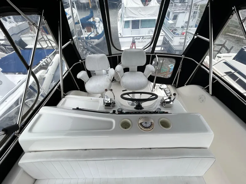 Slide: The Image of Cockpit of 2000 Riviera 34 Convertible yacht with dual captain chairs and steering wheel. - 15