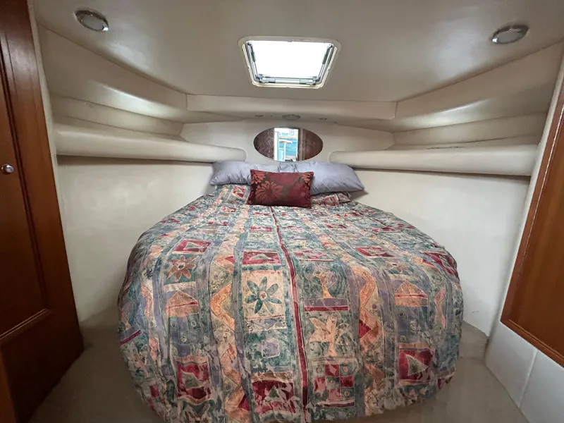 Slide: The Image of Cozy cabin interior of 2000 Riviera 34 Convertible with patterned bedding and overhead hatch. - 22