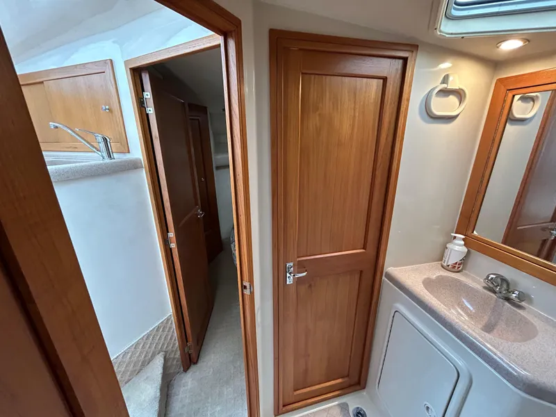 Slide: The Image of Interior of 2000 Riviera 34 Convertible yacht bathroom with wooden doors and sink. - 25