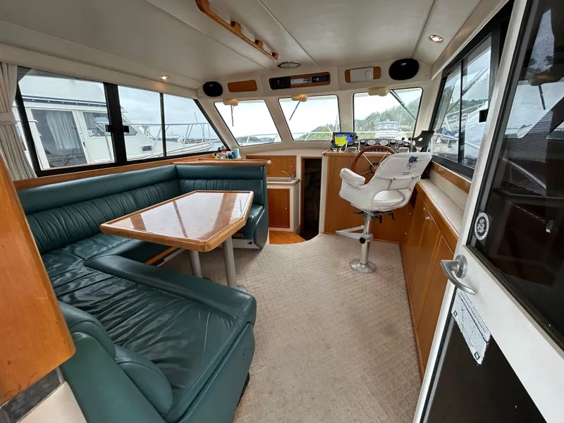 Slide: The Image of Interior of 2000 Riviera 34 Convertible yacht with green seating and wooden accents. - 34