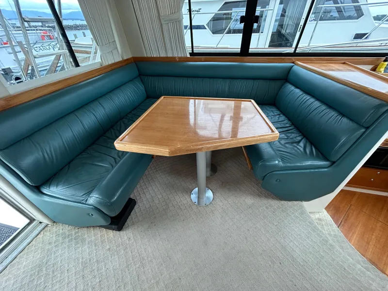 Slide: The Image of Luxurious seating area in a 2000 Riviera 34 Convertible yacht with teal leather upholstery. - 35