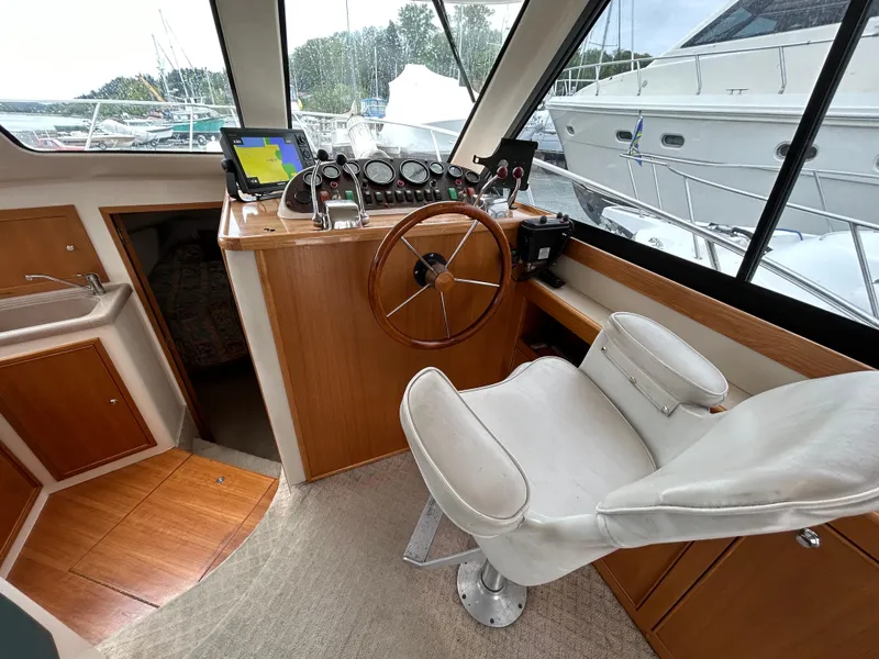 Slide: The Image of Interior of 2000 Riviera 34 Convertible yacht with helm, steering wheel, and navigation equipment. - 36