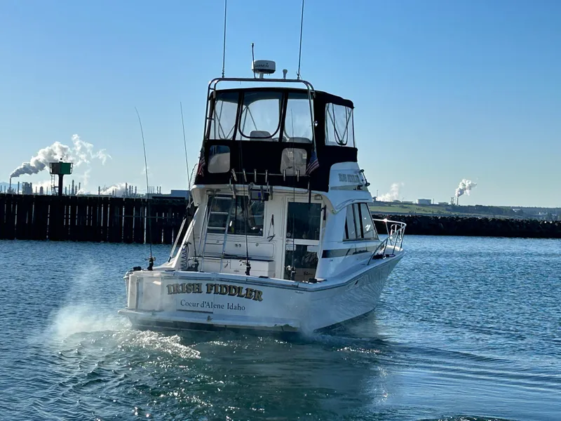 Slide: The Image of Riviera 34 Convertible boat from 2000 on water, with industrial background. - 6