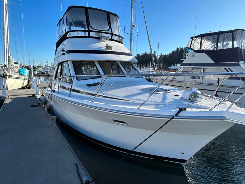 Slide: The Image of 2000 Riviera 34 Convertible yacht docked at marina under clear blue sky. - 9