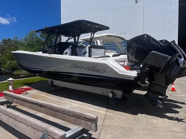 The Image of 2022 Nor-Tech 390 Sport Center Console boat on trailer, outdoor setting, sunny day. - 0