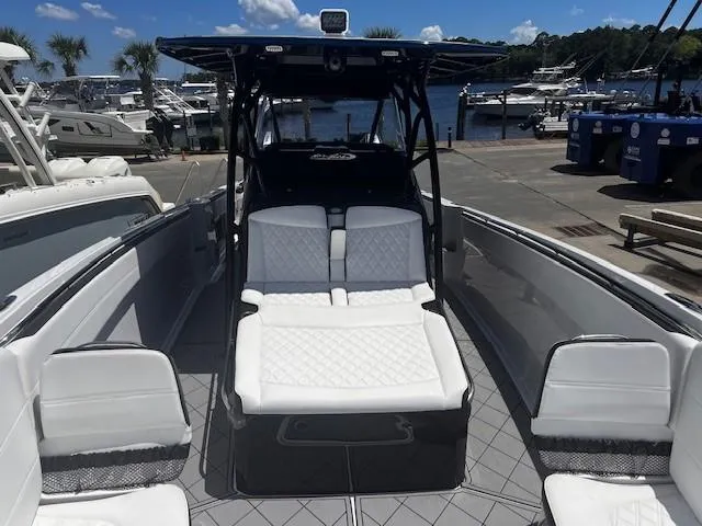 Slide: The Image of 2022 Nor-Tech 390 Sport Center Console boat with luxurious seating at a marina. - 17
