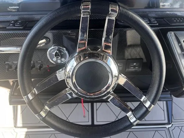 Slide: The Image of Steering wheel of 2022 Nor-Tech 390 Sport Center Console boat, featuring sleek design and controls. - 9