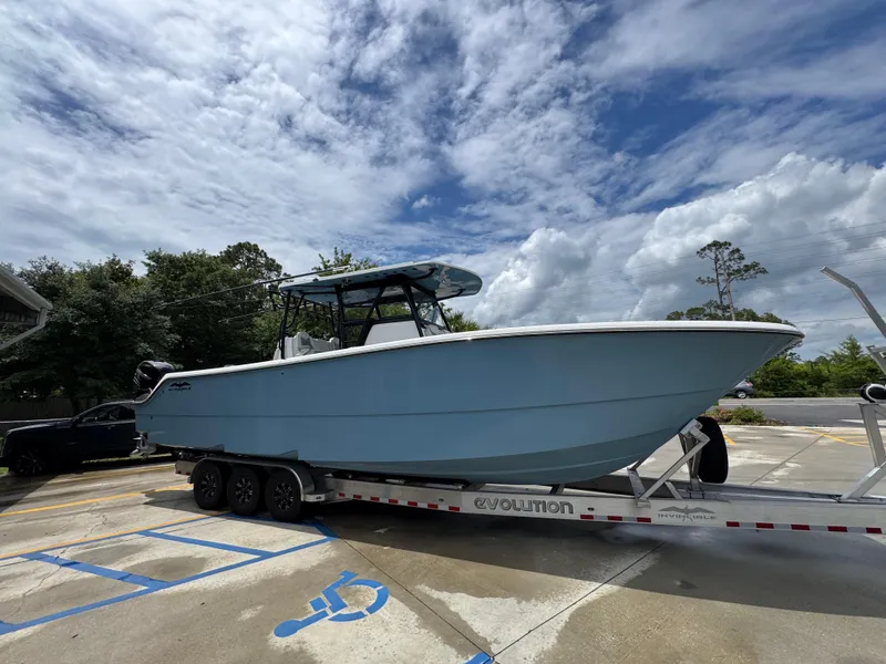 Slide: The Image of 2022 Invincible 33 Catamaran on trailer under cloudy sky. - 10