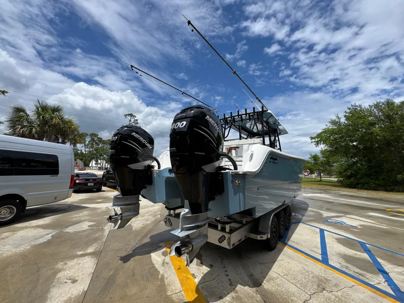 Slide: The Image of 2022 Invincible 33 Catamaran with dual outboard engines in a parking lot. - 14