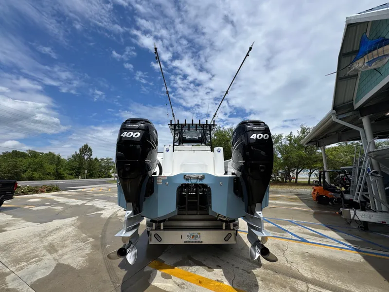 Slide: The Image of 2022 Invincible 33 Catamaran with twin 400 horsepower engines, parked outdoors under a cloudy sky. - 16