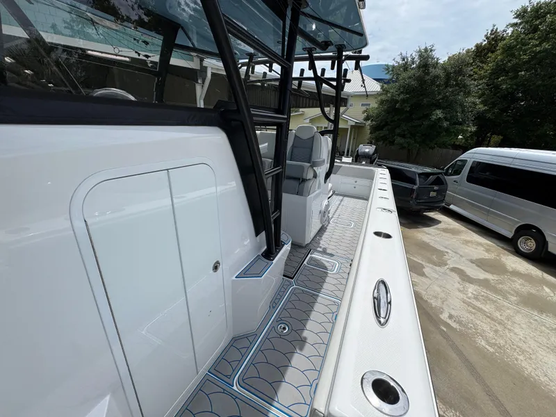 Slide: The Image of 2022 Invincible 33 Catamaran, sleek design, spacious deck, parked outdoors. - 25