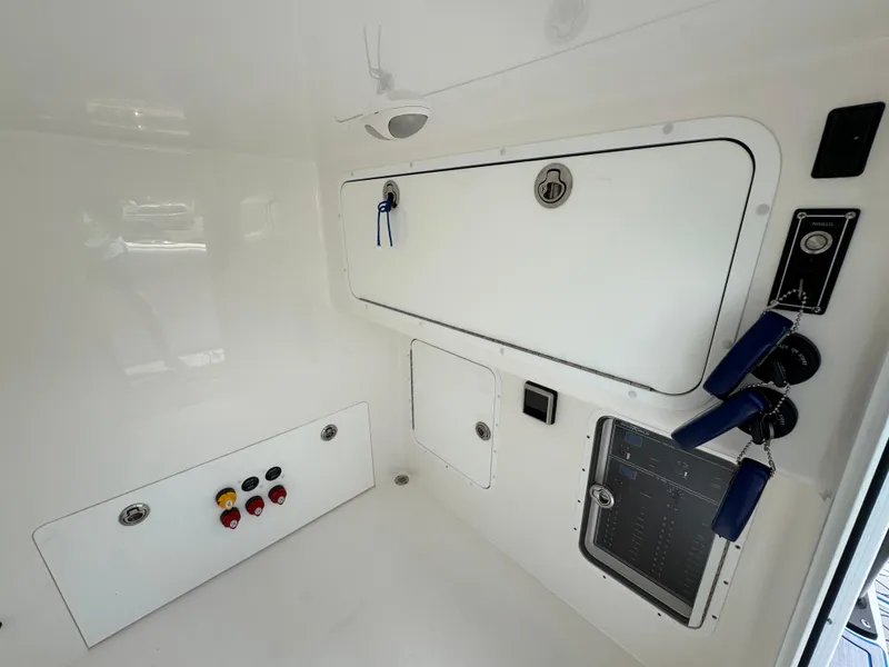 Slide: The Image of 2022 Invincible 33 Catamaran interior with control panels and storage compartments. - 28