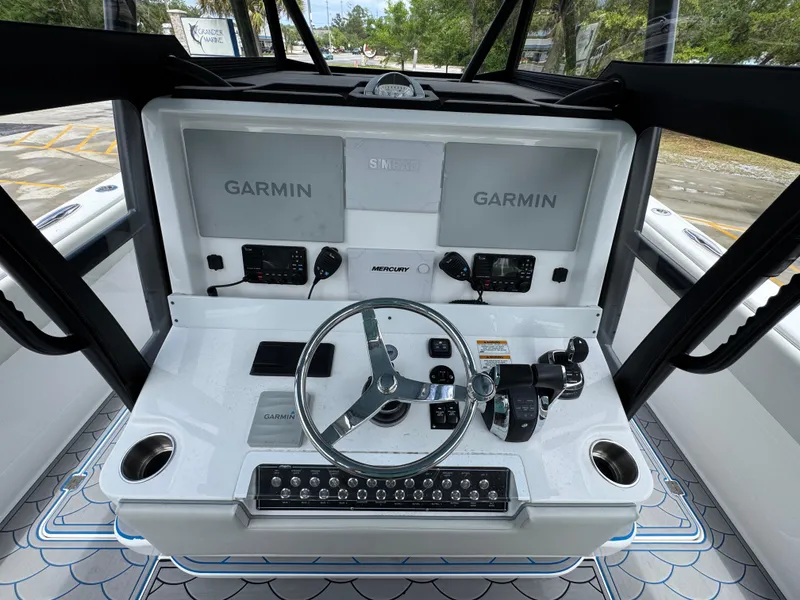Slide: The Image of 2022 Invincible 33 Catamaran helm with dual Garmin displays and Mercury controls. - 33