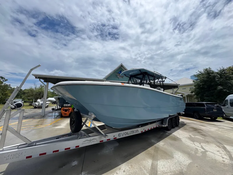 Slide: The Image of 2022 Invincible 33 Catamaran on trailer under cloudy sky. - 4