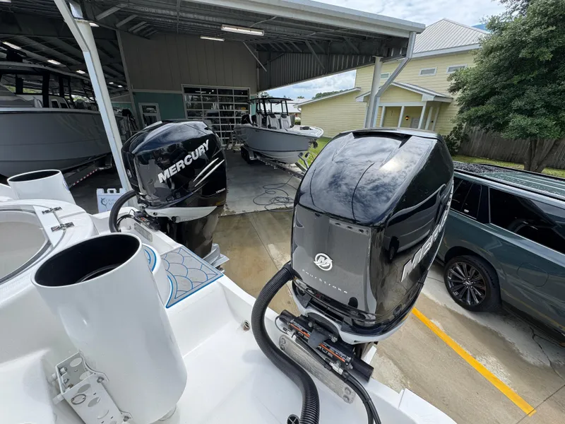 Slide: The Image of 2022 Invincible 33 Catamaran with dual Mercury outboard engines in a boatyard setting. - 42