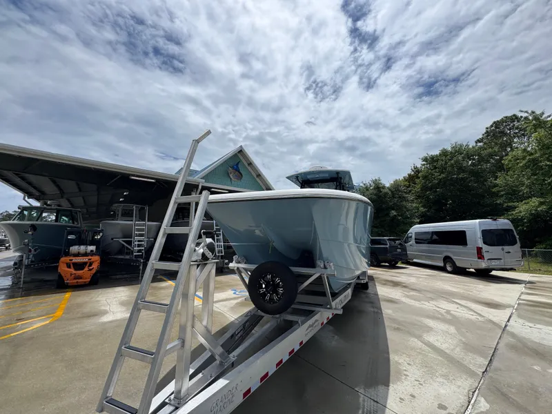 Slide: The Image of 2022 Invincible 33 Catamaran on trailer under cloudy sky at a marina. - 6