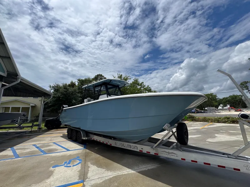 Slide: The Image of 2022 Invincible 33 Catamaran on trailer under cloudy sky. - 9