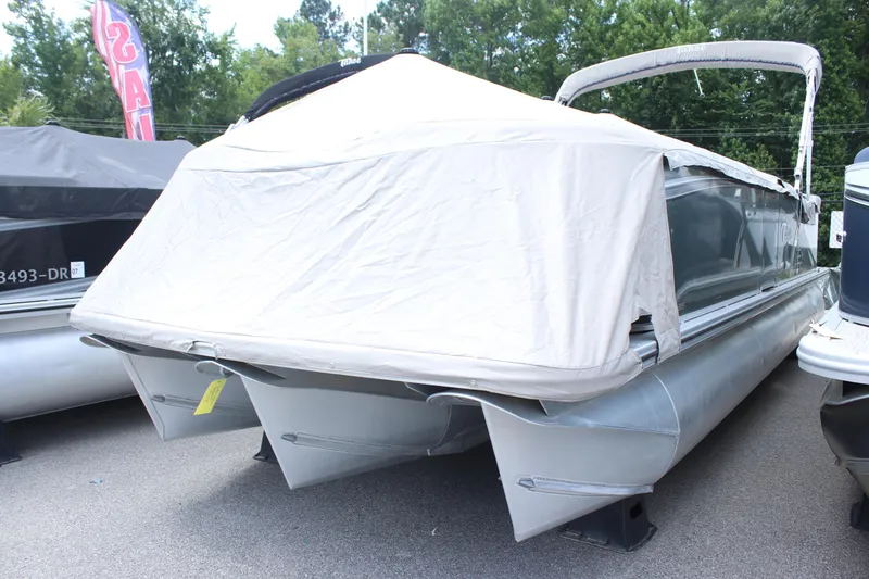 Slide: The Image of 2021 Tahoe LTZ Cruise pontoon boat with cover, parked outdoors. - 14