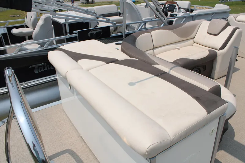 Slide: The Image of 2021 Tahoe LTZ Cruise boat with beige and brown seating, docked outdoors. - 6