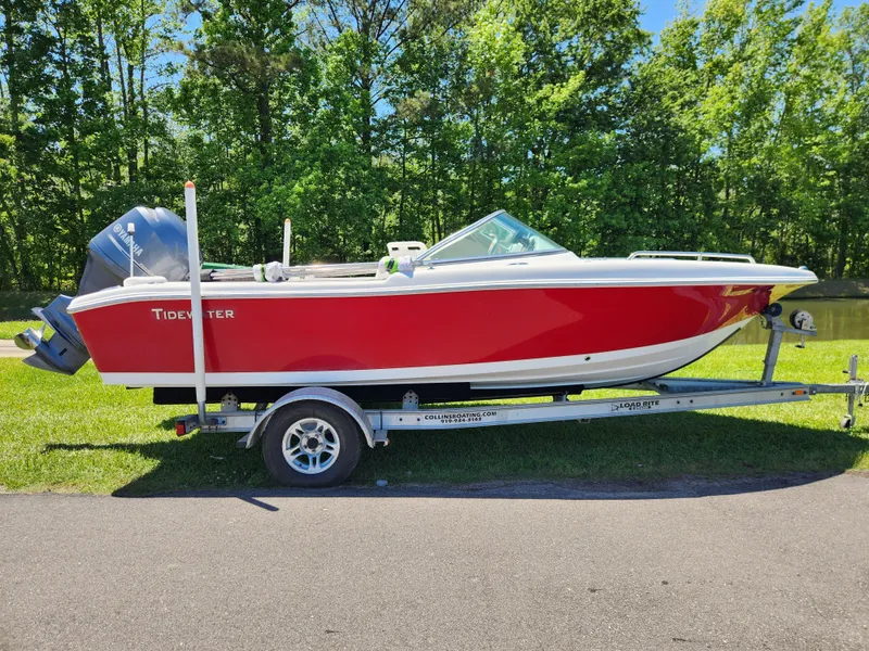 Slide: The Image of 2014 Tidewater 196 DC boat on trailer, red and white, parked outdoors. - 0