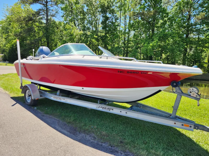 Slide: The Image of 2014 Tidewater 196 DC boat on trailer, red and white, parked outdoors. - 1