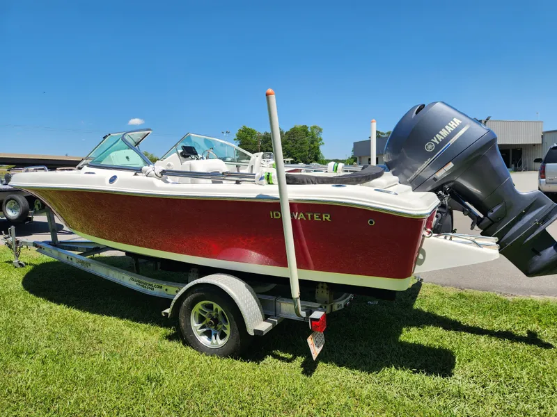 Slide: The Image of Red 2014 Tidewater 196 DC boat on trailer with Yamaha outboard motor, parked on grass. - 4