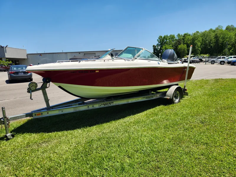 Slide: The Image of 2014 Tidewater 196 DC boat on trailer, parked on grass under clear blue sky. - 6