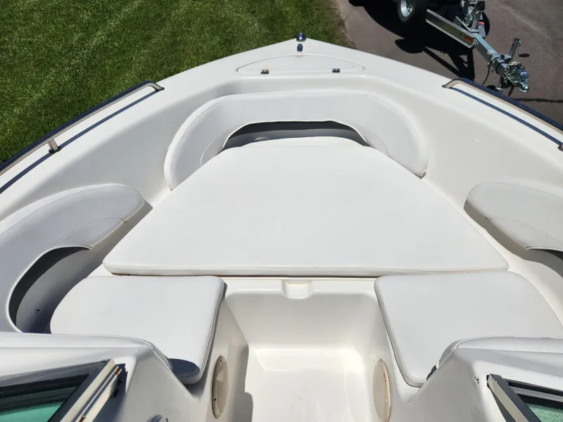 Slide: The Image of 2014 Tidewater 196 DC boat interior with white cushioned seating and trailer in background. - 7