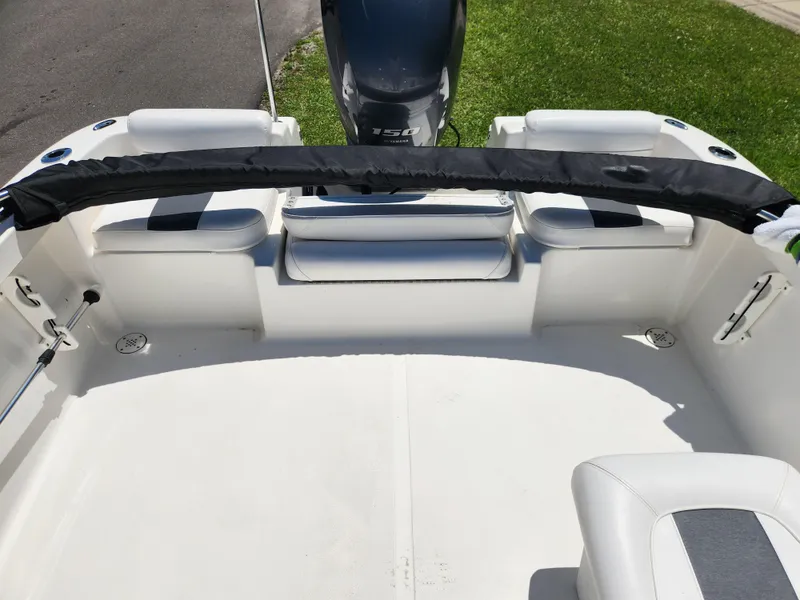 Slide: The Image of 2014 Tidewater 196 DC boat interior with seating and motor, parked on grass. - 9