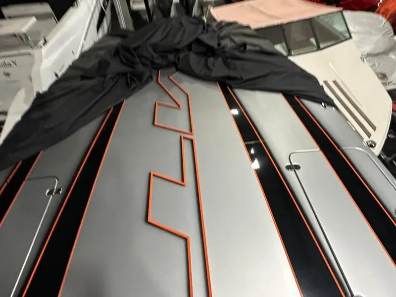 Slide: The Image of 2018 MTI 340X boat with sleek black and orange design, partially covered. - 13