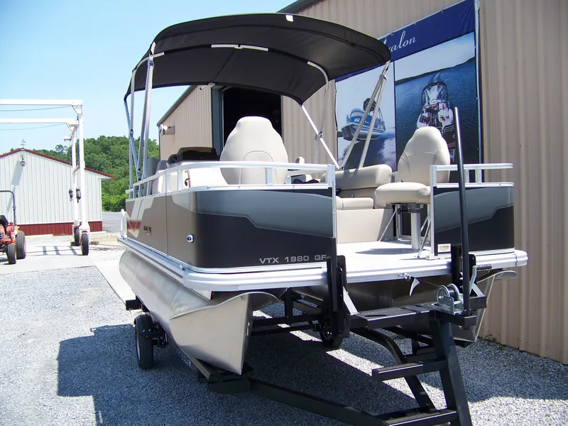 Slide: The Image of 2025 Avalon VTX Quad Fish pontoon boat on trailer, outdoor display. - 3