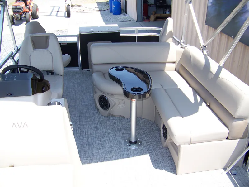 Slide: The Image of 2025 Avalon VTX Quad Fish boat interior with beige seating and sleek black table. - 4