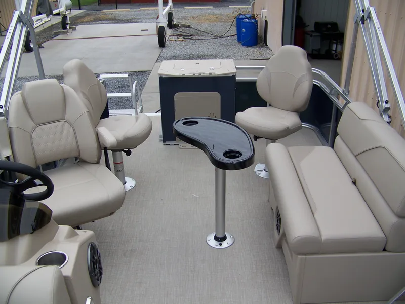 Slide: The Image of 2025 Avalon Venture Rear Fish boat interior with beige seating and a central table. - 4