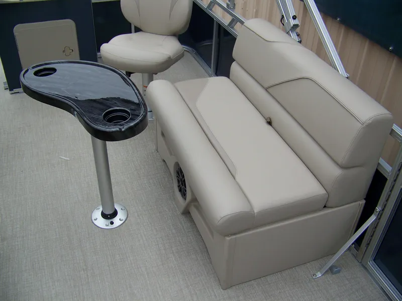 Slide: The Image of 2025 Avalon Venture Rear Fish boat interior with beige seating and black table. - 6