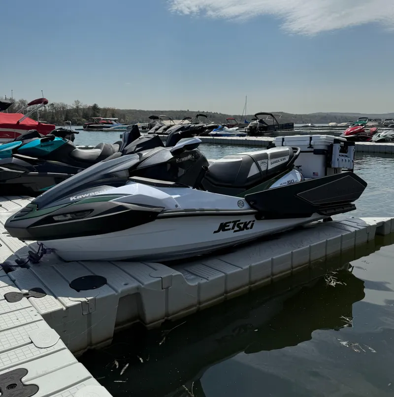 Slide: The Image of 2025 Kawasaki Ultra 160LX-S Angler jet ski docked at a marina under a partly cloudy sky. - 3