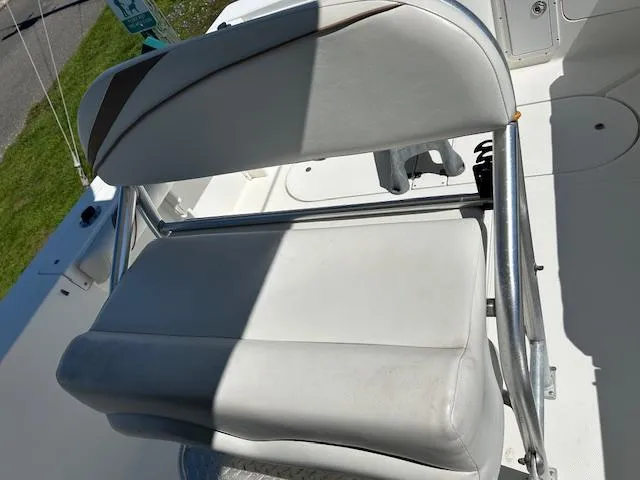 Slide: The Image of White seat on 2003 Aquasport 250 Osprey boat, featuring metal frame and cushioned backrest. - 11