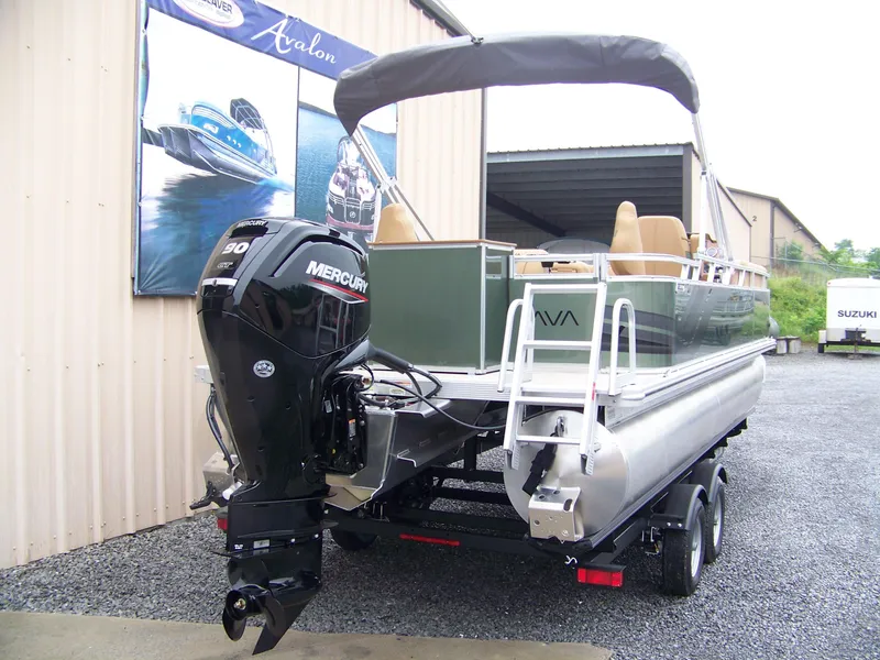 Slide: The Image of 2025 Avalon Venture Rear Fish pontoon boat with Mercury engine, parked on a trailer. - 3