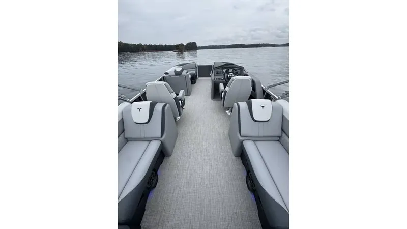 Slide: The Image of 2025 Tahoe Pontoon LTZ Quad Lounger on a serene lake, showcasing spacious seating. - 10